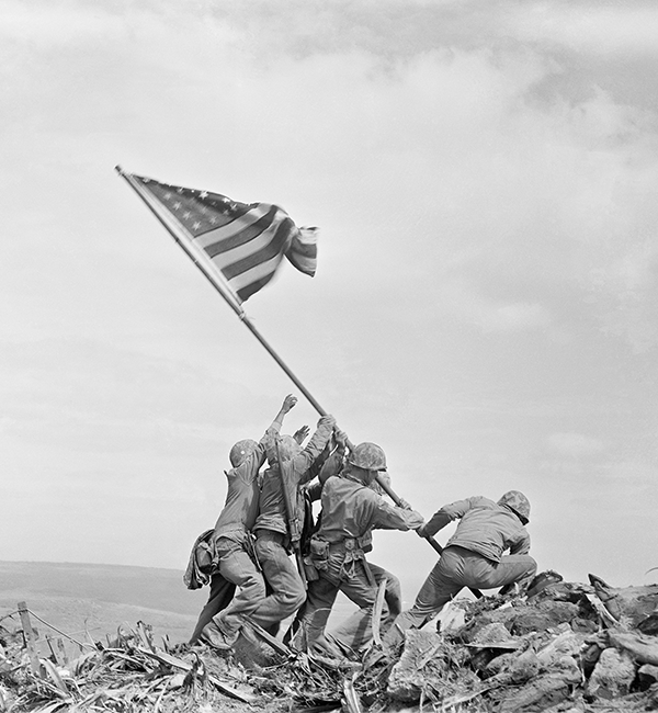 black and white photo of soldiers putting up an American flag